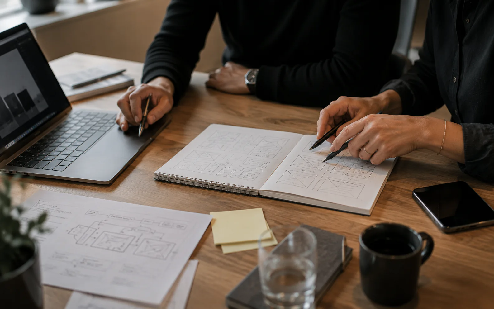 Planering av ett digitalt projekt med laptop, anteckningar och wireframes